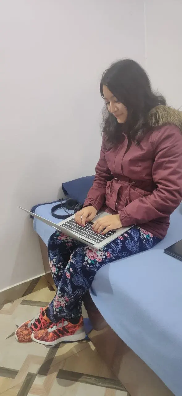 An adult woman working at a laptop